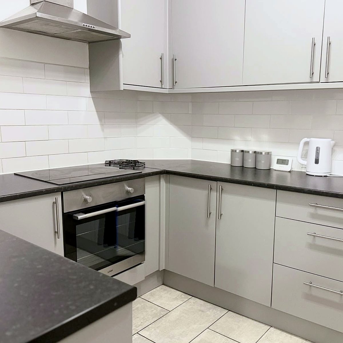 Grey shaker kitchen with black worktops and metro tiles