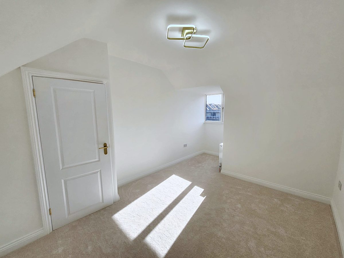 Bright loft bedroom with new carpet and sunlight on the floor