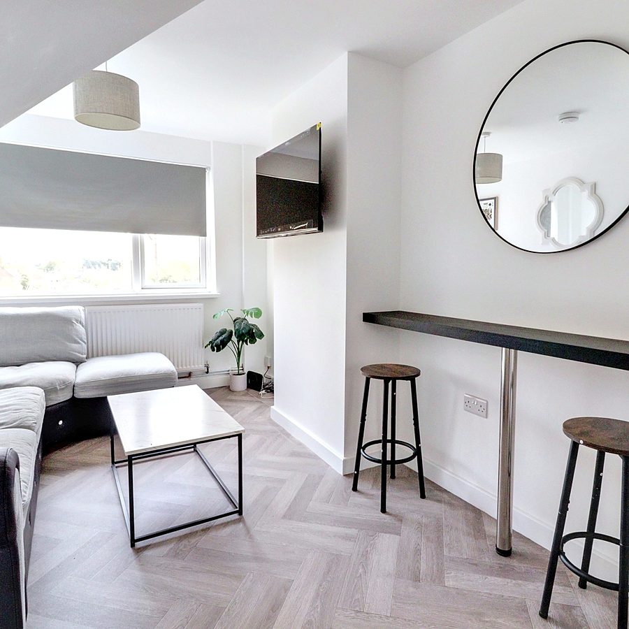 Lounge with corner sofa, wall-mounted TV and breakfast bar